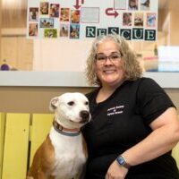 JR_Roxie Happy volunteer sitting with a dog on a bench